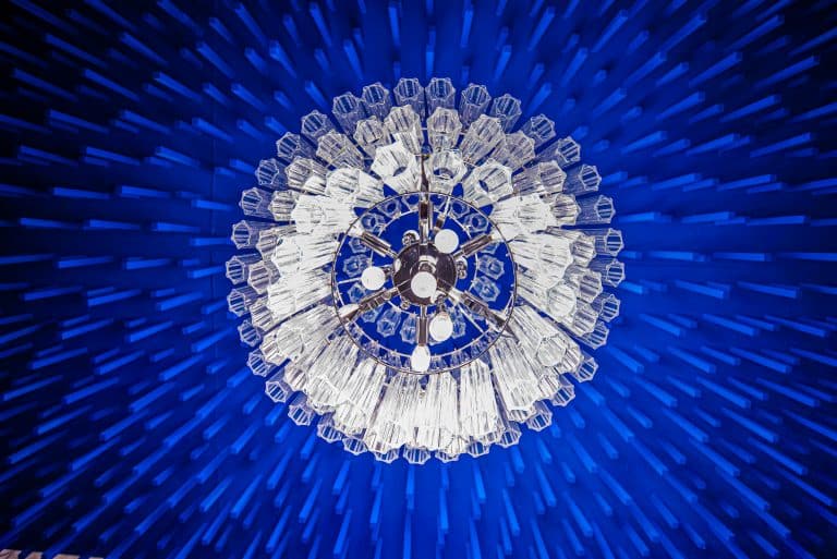 70's inspired crystal chandelier lights up vivid blue custom texture ceiling